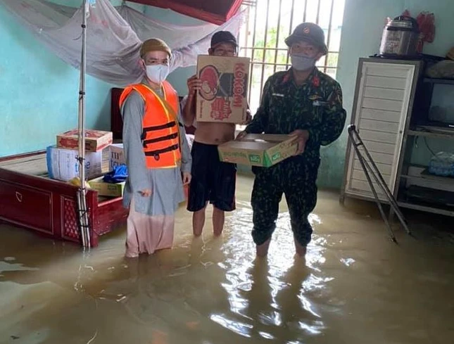 Đại đức Thích Tâm Ngọc, trụ trì chùa Yên Thái trao nhu yếu phẩm tới người dân xã Quỳnh Diễn