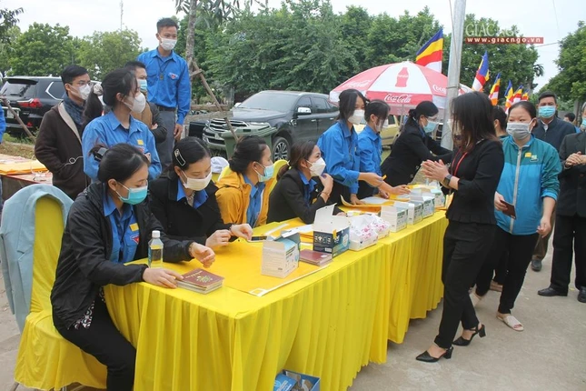 Các tình nguyện viên xịt nước sát khuẩn tay cho người dân trước khi vào khán đài