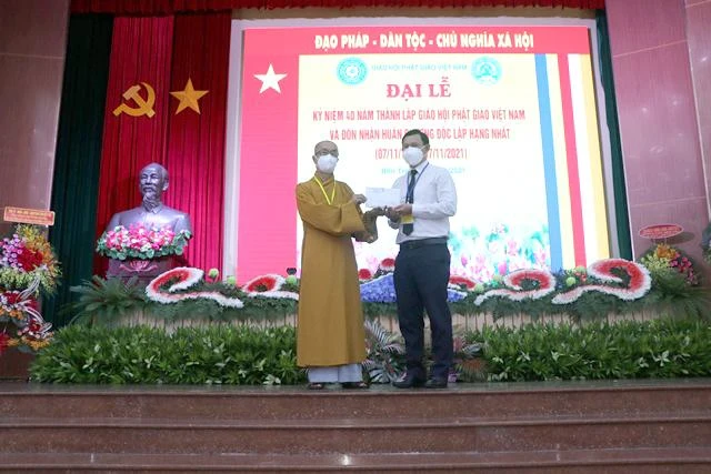 Ông Nguyễn Phúc Linh, Quyền Chủ tịch Ủy ban MTTQVN tỉnh Bến Tre đón nhận số tiền mặt 50 triệu đồng do Hòa thượng Thích Nhựt Tấn thay mặt Ban Trị sự Phật giáo tỉnh Bến Tre trao tặng