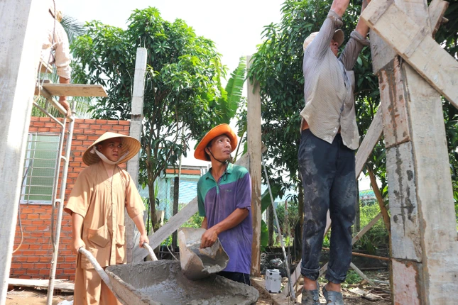 Đại đức Thích Minh Lộc cùng các bạn sinh viên tình nguyện trực tiếp tham gia thi công ngôi nhà mơ ước cho anh Nguyễn Trọng Hiếu