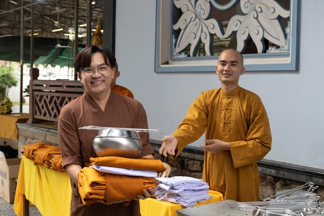 Nghệ sĩ Đại Nghĩa nhận y, bát trước khi làm lễ thế phát trong khóa xuất gia gieo duyên mùa Đông tại chùa Huyền Không - Ảnh: M.Giải