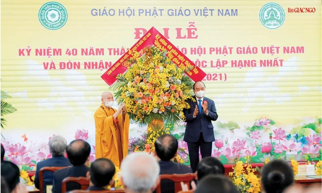 Hòa thượng Thích Thiện Nhơn, Chủ tịch Hội đồng Trị sự đón nhận lẵng hoa chúc mừng của lãnh đạo Đảng, Nhà nước, Mặt trận Tổ quốc VN do Chủ tịch nước Nguyễn Xuân Phúc tặng tại Đại lễ Kỷ niệm 40 năm thành lập GHPGVN - Ảnh: Bảo Trinh