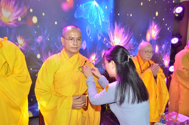 Đoàn sinh Gia đình Phật tử Viên Quang cài hoa hồng lên huỳnh y chu tôn đức