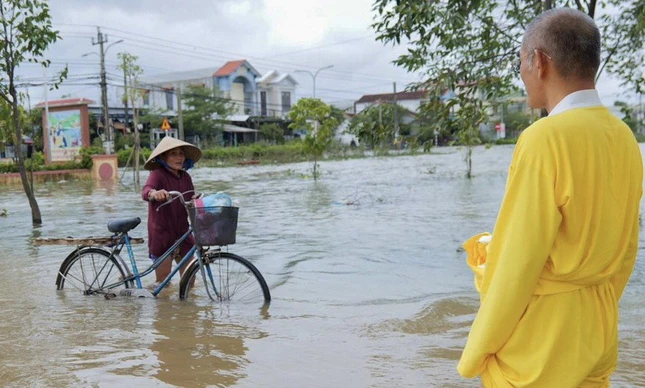 Một cụ già lội nước đi nhận quà