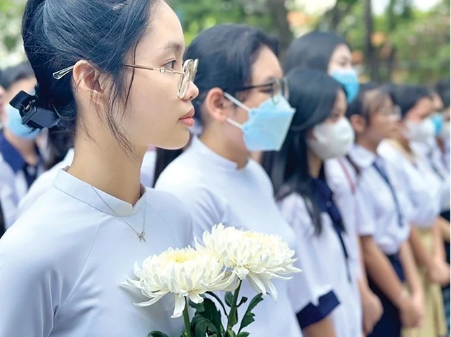 Các nữ sinh nhận học bổng (năm 2023) với cành hoa cúc trắng tưởng nhớ liệt nữ Quách Thị Trang