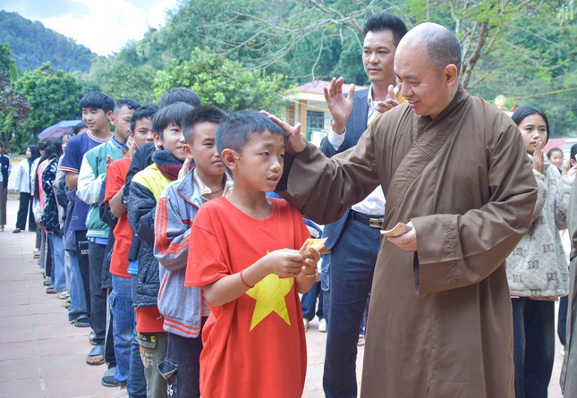 Một em học sinh vui vẻ nhận quà từ Thượng tọa Thích Đức Thiện