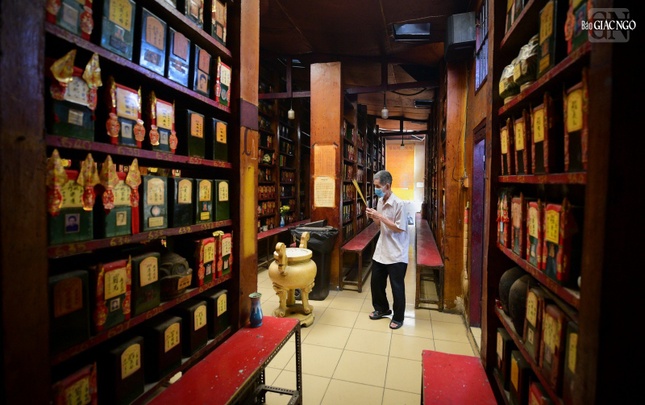 Một người dân đang thắp hương cho người đã mất tại nơi thờ tro cốt của chùa