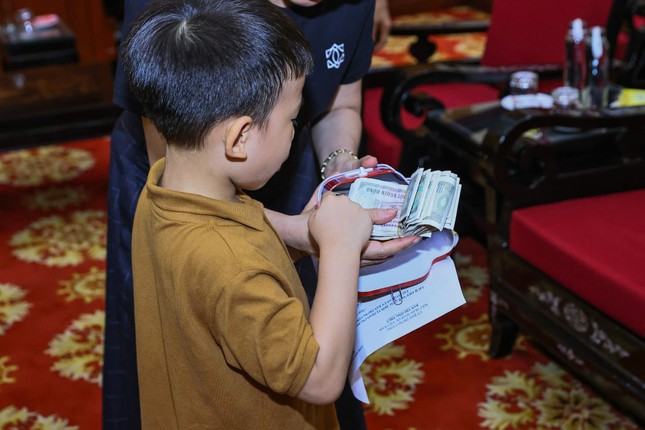 Cháu Lê Hải Lâm 5 tuổi cầm cọc tiền lẻ vừa khui từ "con lợn đất" của mình để ủng hộ đồng bào bão lũ