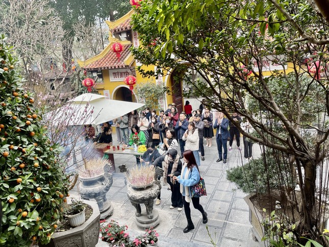 Rất đông du khách và người dân đến chùa Quán Sứ trong ngày rằm tháng Giêng. Khói hương nghi ngút tỏa ra từ những bát hương, hòa quyện với tiếng chuông chùa ngân vang, tạo nên bầu không khí trang nghiêm, thanh tịnh - Ảnh: Phương Bùi