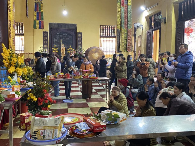 Một số người chuẩn bị mâm lễ cúng, bao gồm bánh trái, thẻ hương để dâng lên các bàn thờ tại chùa Quán Sứ - Ảnh: Hương Uyên