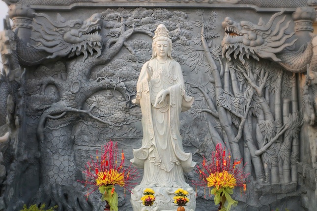 Tượng Bồ-tát Quán Âm tại chùa Liên Hoa (X.Tân Tây, H.Gò Công Đông, Tiền Giang). Phía sau tôn tượng, trên bức phù điêu là hình ảnh cây tre quen thuộc của làng quê Việt Nam, còn cặp rồng biểu trưng sự mạnh mẽ, uy vũ