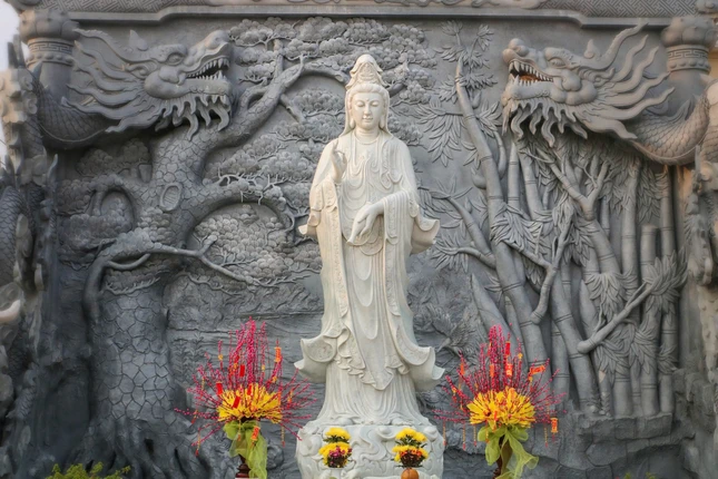 Tượng Bồ-tát Quán Âm tại chùa Liên Hoa (X.Tân Tây, H.Gò Công Đông, Tiền Giang). Phía sau tôn tượng, trên bức phù điêu là hình ảnh cây tre quen thuộc của làng quê Việt Nam, còn cặp rồng biểu trưng sự mạnh mẽ, uy vũ