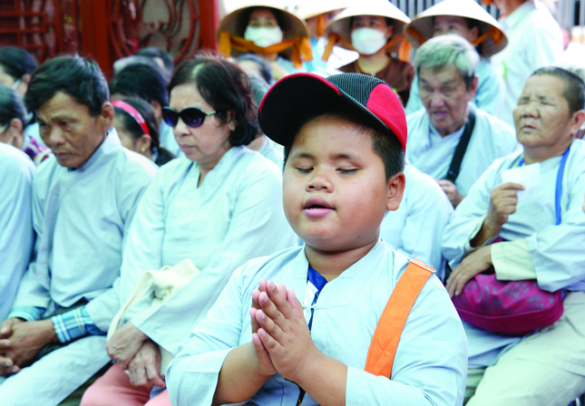 Cậu bé mù 10 tuổi Nguyễn Minh Thịnh niệm Phật khi cùng Hội Người mù tham dự lễ Vu lan tại chùa Từ Mãn - Ảnh: Bảo Toàn