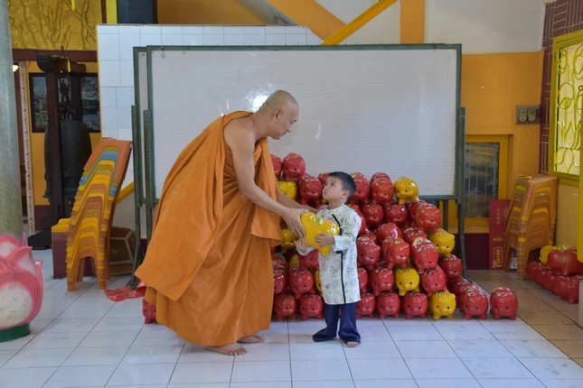 Em bé trao heo đất gây quỹ từ thiện