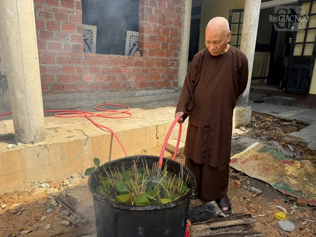 Trưởng lão Hòa thượng Thích Giác Quang cho nước vào nồi bánh để nhóm lửa nấu bánh chưng, bánh tét truyền thống Trưởng lão Hòa thượng Thích Giác Quang cho nước vào nồi bánh để nhóm lửa nấu bánh chưng, bánh tét truyền thống