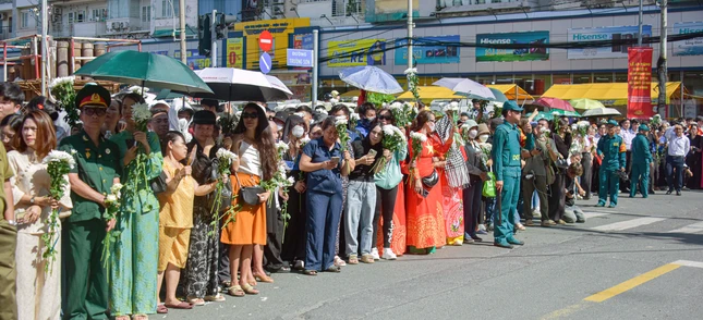 Người dân tay cầm nhành hoa trắng, đứng đợi dưới trời nắng nóng để tiễn đưa các anh hùng liệt sĩ - Ảnh: Quảng Đạo Người dân tay cầm nhành hoa trắng, đứng đợi dưới trời nắng nóng để tiễn đưa các anh hùng liệt sĩ - Ảnh: Quảng Đạo