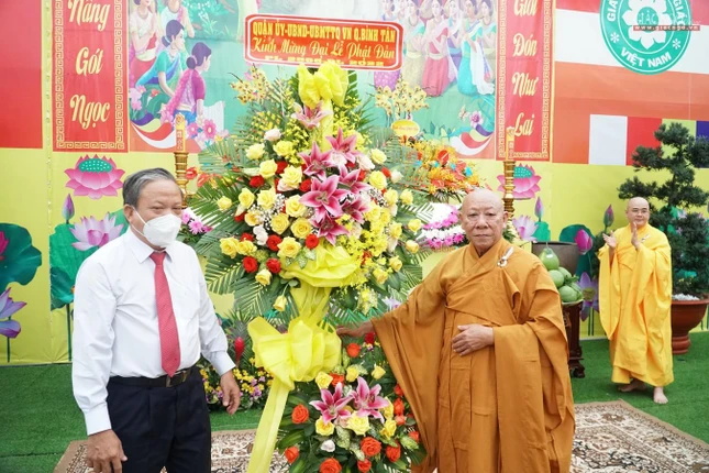 Ông Lê Văn Bảy tặng hoa của lãnh đạo quận chúc mừng Phật đản