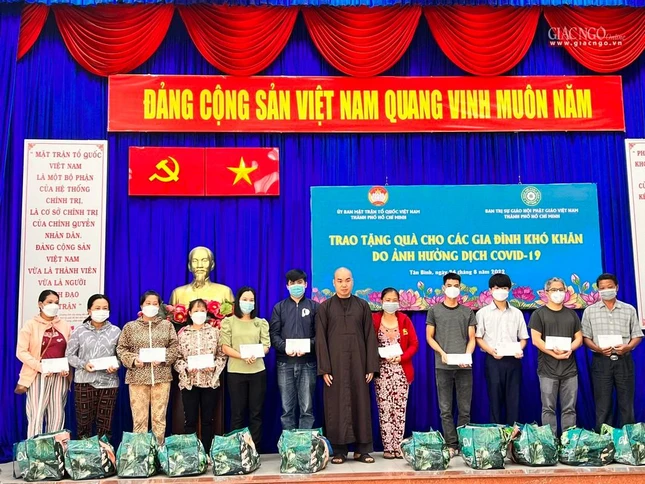 Đại đức Thích Quảng Hậu, Phó Thư ký kiêm Chánh Văn phòng Phật giáo quận Tân Bình trao quà đến các hộ trên đia bàn