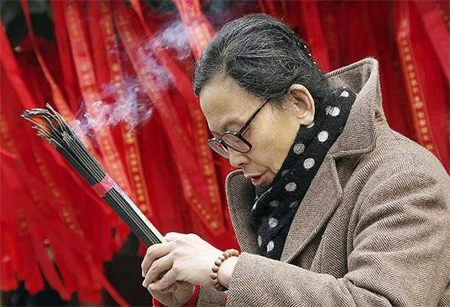 Đã có thời, các hội chùa ở Trung Quốc được tổ chức quanh năm ở hàng trăm ngôi chùa khắp Bắc Kinh. Giờ đây, phần lớn lễ hội diễn ra trong dịp năm mới khi cả nước được nghỉ lễ ba ngày trọn vẹn. Trong ảnh là toàn cảnh ngôi chùa ở Bắc Kinh tấp nập người qua lại trong ngày đầu xuân. Ảnh: Reuters. Người đi chùa chạm vào bức tượng con trâu để cầu may. Ảnh: AP. Cậu bé Trung Quốc mặc trang phục truyền thống đi lễ chùa. Ảnh: Reuters. Các tiết mục biểu diễn truyền thống thu hút được nhiều người xem nhất ở lễ hội. Trong ảnh, nữ diễn viên đội mũ miện trong lúc đang hát múa ở hội tại Bắc Kinh. Ảnh: Reuters. Bên ngoài, trẻ em nô đùa trên hồ bị đóng băng. Ảnh: Reuters. Hai người đàn ông mặc trang phục truyền thống, biểu diễn trong lễ hội. Ảnh: AP. Người phụ nữ thắp hương cầu may trong chùa ở Thượng Hải. Ảnh: Getty Images. Đám đông đi giữa hàng cây trong lễ hội ở Bắc Kinh. Ảnh: Reuters.