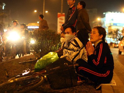 Không còn chỗ gửi xe, người phụ nữ ngày ngồi trên giải phân cách cầu vượt Ngã Tư Sở vừa làm lễ vừa trông xe. Không còn chỗ gửi xe, người phụ nữ ngày ngồi trên giải phân cách cầu vượt Ngã Tư Sở vừa làm lễ vừa trông xe.