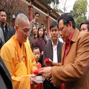 Ô. Lại Hồng Khánh - Trưởng ban Tuyên giáo Thành ủy trao Huy hiệu Thành phố vì hòa bình và tặng sách cho Đại đức Thích Minh Hiền - trụ trì chùa Hương