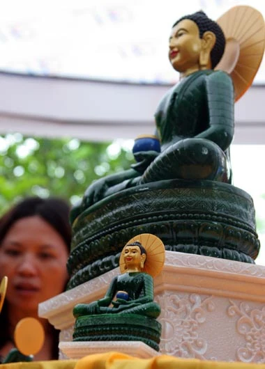 Tượng Phật ngọc tọa lạc trên đài sen trong ngôi chùa cổ miền Bắc. Hai ngày sau khi mở cửa tự do để người dân chiêm bái tượng Phật ngọc, lượng người kéo đến đây vẫn khá đông. Dù lượng người đến xem đông nhưng theo anh thanh niên này, ảnh tượng Phật ngọc bán không đắt hàng. "Xuống giá 10.000 đồng một ảnh to một ảnh nhỏ nhưng cũng chẳng mấy người mua. Từ sáng tới giờ tôi mới bán được chừng 300 tấm", người này nói. Tương tự, các cửa hàng bán tranh tượng Phật in trên gỗ, ảnh tượng Phật in trên đá... cũng ế ẩm. Trong khi đó, một công ty chuyên kinh doanh quà tặng đã chép nguyên mẫu tượng Phật ngọc để đúc lại với kích cỡ nhỏ hơn. Dù không phải làm thủ công mà được đúc bằng bột đá nhưng giá một bức tượng cao chừng 50 cm là 5 triệu đồng, còn bức tượng nhỏ bằng bàn tay giá 300.000 đồng. Loại tượng đặc biệt này đã thu hút sự chú ý của người xem. Tuy nhiên, nhiều người cũng chỉ dám cầm lên xem rồi đặt xuống... ... hay chụp bức ảnh làm kỷ niệm, thay vì chụp bức ảnh Phật ngọc nguyên mẫu được đặt ở quá xa. Dịch vụ chụp ảnh lấy ngay trong 5 phút cũng khá hút khách vì ai cũng muốn có một bức hình làm kỷ niệm nhân dịp tận mắt ngắm bức tượng Phật ngọc lớn nhất thế giới. Còn ở ngoài đường, mỗi khi có ôtô chở khách xịch đỗ là hàng chục người dân đi xe máy chạy tới mời đi xe ôm giá 10.000 - 15.000 đồng một lượt cho quãng đường 5-6 km. Nếu không đi xe ôm, du khách sẽ phải đi bộ vài km mới tới được nơi bày tượng Phật.