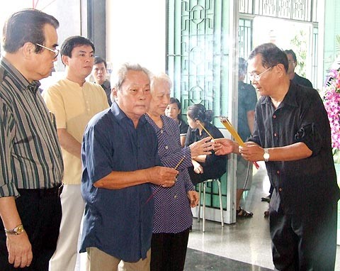 Nhà văn Nguyễn Quang Sáng (thứ hai từ trái qua) bịn rịn trước bàn thờ người em nhạc sĩ.