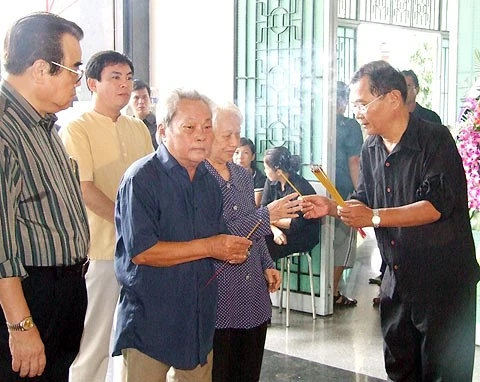 Nhà văn Nguyễn Quang Sáng (thứ hai từ trái qua) bịn rịn trước bàn thờ người em nhạc sĩ.