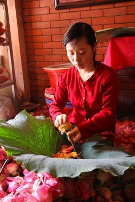 Lá sen và ngó sen được bóc tách ra để lộ ra phần sợi nhị vàng có gạo sen ở đầu Mô tả ảnh.