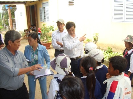 Anh Nở (bên trái) tặng quà cho học sinh nghèo.jpg.JPG