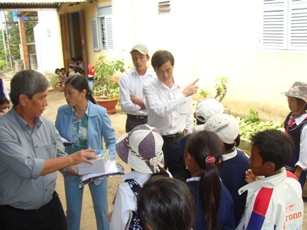 Anh Nở (bên trái) tặng quà cho học sinh nghèo.jpg.JPG