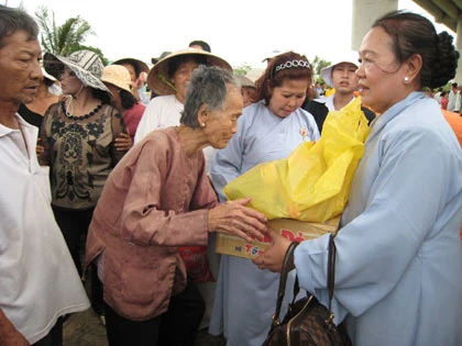Bà Cao Thị Thẳng (bìa phải) trao quà cho 200 hộ nghèo ở huyện Bình Minh.