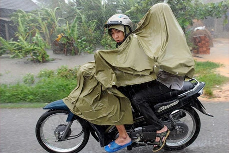 Hai thanh niên đi trong mưa bão ở Huế. (Ảnh: AFP)