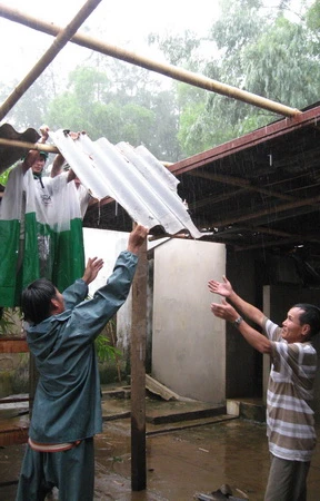 Ngay khi cơn lốc đi qua, người dân thôn Phú Xuân, Hải Lăng tranh thủ lợp lại nhà - Ảnh: Hiếu Giang
