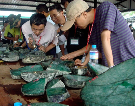 Các chuyên gia xem đá tại chợ đấu giá đá quý ở Myanmar.