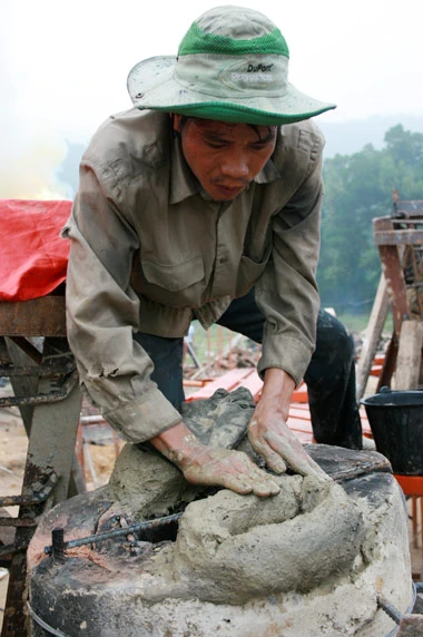 Từ sáng sớm, hàng nghìn người đã đổ về khu đúc tượng cạnh Học viện Phật giáo VN (Sóc Sơn, Hà Nội). Theo lịch âm, hôm nay là ngày "trùng cửu", ngày có ý nghĩa thiêng liêng đặc biệt, rất thích hợp để tiến hành đúc tượng Thánh Gióng - Đức Thánh Phù Đổng Thiên vương. Một mô hình thu nhỏ đặt cạnh khu đúc tượng để phật tử làm lễ, chiêm bái. Khi hoàn thành, tượng cao gần 11 m, độ vươn chéo lên trời khoảng 16 m. Rất nhiều người góp trang sức bằng kim loại quý để hòa cùng dòng đồng nóng chảy lúc đổ vào khuôn. Tại khu đất được cách ly cạnh đó, hai chiếc khuôn của phần đầu ngựa và thân trên Thánh Gióng đang gấp rút được hoàn tất những khâu cuối cùng. Đây là 2 thớt đầu tiên được đúc của tượng đài. Một số chi tiết khác của tượng đài cũng được làm trong mẻ đầu tiên. Hàng trăm thanh đồng đỏ nguyên chất được nung chảy trong lò ga hơn 1.000 độ C. Theo các nghệ nhân, thời gian từ lúc nấu đến lúc đổ đồng mất hơn 2 giờ. Người nghệ nhân cẩn thận trát kín mạch và tạo miệng khuôn để đổ đồng nóng chảy vào. Sau 2 giờ nung, mẻ đồng nóng chảy đổ ra... ...trong khi các nghệ nhân kính cẩn thắp hương mong mọi việc suôn sẻ. Bên ngoài hàng rào, hàng nghìn người chen lấn mong được vào chiêm ngưỡng cận cảnh. Tới dự buổi lễ sáng nay có nguyên Tổng bí thư Đỗ Mười, cùng nhiều vị lãnh đạo. Ngay trước thời khắc 9h9, hòa thượng Thích Thanh Tứ, Phó chủ tịch Trung ương hội Phật giáo VN(người đeo tràng hạt) cùng nhiều quan chức tiến vào khu đúc tượng. Hàng trăm món đồ kim loại quý được thả vào khuôn... ... trước khi dòng đồng đỏ nóng chảy được rót. Theo các nghệ nhân, công đoạn khó nhất của quá trình đúc tượng là khâu làm khuôn: mất 2 tháng. Khuôn phải làm sao để toát lên được thần thái của Thánh Gióng và toàn bộ hoa văn, họa tiết tinh xảo của tượng với đúng tỉ lệ 1:1. Sau khi đổ đầy đồng vào khuôn, cần tới 4 ngày để làm nguội tự nhiên rồi mới phá khuôn.