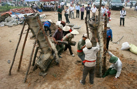 Từ sáng sớm, hàng nghìn người đã đổ về khu đúc tượng cạnh Học viện Phật giáo VN (Sóc Sơn, Hà Nội). Theo lịch âm, hôm nay là ngày "trùng cửu", ngày có ý nghĩa thiêng liêng đặc biệt, rất thích hợp để tiến hành đúc tượng Thánh Gióng - Đức Thánh Phù Đổng Thiên vương. Một mô hình thu nhỏ đặt cạnh khu đúc tượng để phật tử làm lễ, chiêm bái. Khi hoàn thành, tượng cao gần 11 m, độ vươn chéo lên trời khoảng 16 m. Rất nhiều người góp trang sức bằng kim loại quý để hòa cùng dòng đồng nóng chảy lúc đổ vào khuôn. Tại khu đất được cách ly cạnh đó, hai chiếc khuôn của phần đầu ngựa và thân trên Thánh Gióng đang gấp rút được hoàn tất những khâu cuối cùng. Đây là 2 thớt đầu tiên được đúc của tượng đài. Một số chi tiết khác của tượng đài cũng được làm trong mẻ đầu tiên. Hàng trăm thanh đồng đỏ nguyên chất được nung chảy trong lò ga hơn 1.000 độ C. Theo các nghệ nhân, thời gian từ lúc nấu đến lúc đổ đồng mất hơn 2 giờ. Người nghệ nhân cẩn thận trát kín mạch và tạo miệng khuôn để đổ đồng nóng chảy vào. Sau 2 giờ nung, mẻ đồng nóng chảy đổ ra... ...trong khi các nghệ nhân kính cẩn thắp hương mong mọi việc suôn sẻ. Bên ngoài hàng rào, hàng nghìn người chen lấn mong được vào chiêm ngưỡng cận cảnh. Tới dự buổi lễ sáng nay có nguyên Tổng bí thư Đỗ Mười, cùng nhiều vị lãnh đạo. Ngay trước thời khắc 9h9, hòa thượng Thích Thanh Tứ, Phó chủ tịch Trung ương hội Phật giáo VN(người đeo tràng hạt) cùng nhiều quan chức tiến vào khu đúc tượng. Hàng trăm món đồ kim loại quý được thả vào khuôn... ... trước khi dòng đồng đỏ nóng chảy được rót. Theo các nghệ nhân, công đoạn khó nhất của quá trình đúc tượng là khâu làm khuôn: mất 2 tháng. Khuôn phải làm sao để toát lên được thần thái của Thánh Gióng và toàn bộ hoa văn, họa tiết tinh xảo của tượng với đúng tỉ lệ 1:1. Sau khi đổ đầy đồng vào khuôn, cần tới 4 ngày để làm nguội tự nhiên rồi mới phá khuôn.