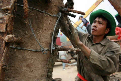 Từ sáng sớm, hàng nghìn người đã đổ về khu đúc tượng cạnh Học viện Phật giáo VN (Sóc Sơn, Hà Nội). Theo lịch âm, hôm nay là ngày "trùng cửu", ngày có ý nghĩa thiêng liêng đặc biệt, rất thích hợp để tiến hành đúc tượng Thánh Gióng - Đức Thánh Phù Đổng Thiên vương. Một mô hình thu nhỏ đặt cạnh khu đúc tượng để phật tử làm lễ, chiêm bái. Khi hoàn thành, tượng cao gần 11 m, độ vươn chéo lên trời khoảng 16 m. Rất nhiều người góp trang sức bằng kim loại quý để hòa cùng dòng đồng nóng chảy lúc đổ vào khuôn. Tại khu đất được cách ly cạnh đó, hai chiếc khuôn của phần đầu ngựa và thân trên Thánh Gióng đang gấp rút được hoàn tất những khâu cuối cùng. Đây là 2 thớt đầu tiên được đúc của tượng đài. Một số chi tiết khác của tượng đài cũng được làm trong mẻ đầu tiên. Hàng trăm thanh đồng đỏ nguyên chất được nung chảy trong lò ga hơn 1.000 độ C. Theo các nghệ nhân, thời gian từ lúc nấu đến lúc đổ đồng mất hơn 2 giờ. Người nghệ nhân cẩn thận trát kín mạch và tạo miệng khuôn để đổ đồng nóng chảy vào. Sau 2 giờ nung, mẻ đồng nóng chảy đổ ra... ...trong khi các nghệ nhân kính cẩn thắp hương mong mọi việc suôn sẻ. Bên ngoài hàng rào, hàng nghìn người chen lấn mong được vào chiêm ngưỡng cận cảnh. Tới dự buổi lễ sáng nay có nguyên Tổng bí thư Đỗ Mười, cùng nhiều vị lãnh đạo. Ngay trước thời khắc 9h9, hòa thượng Thích Thanh Tứ, Phó chủ tịch Trung ương hội Phật giáo VN(người đeo tràng hạt) cùng nhiều quan chức tiến vào khu đúc tượng. Hàng trăm món đồ kim loại quý được thả vào khuôn... ... trước khi dòng đồng đỏ nóng chảy được rót. Theo các nghệ nhân, công đoạn khó nhất của quá trình đúc tượng là khâu làm khuôn: mất 2 tháng. Khuôn phải làm sao để toát lên được thần thái của Thánh Gióng và toàn bộ hoa văn, họa tiết tinh xảo của tượng với đúng tỉ lệ 1:1. Sau khi đổ đầy đồng vào khuôn, cần tới 4 ngày để làm nguội tự nhiên rồi mới phá khuôn.