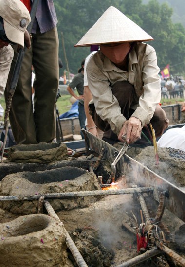 Từ sáng sớm, hàng nghìn người đã đổ về khu đúc tượng cạnh Học viện Phật giáo VN (Sóc Sơn, Hà Nội). Theo lịch âm, hôm nay là ngày "trùng cửu", ngày có ý nghĩa thiêng liêng đặc biệt, rất thích hợp để tiến hành đúc tượng Thánh Gióng - Đức Thánh Phù Đổng Thiên vương. Một mô hình thu nhỏ đặt cạnh khu đúc tượng để phật tử làm lễ, chiêm bái. Khi hoàn thành, tượng cao gần 11 m, độ vươn chéo lên trời khoảng 16 m. Rất nhiều người góp trang sức bằng kim loại quý để hòa cùng dòng đồng nóng chảy lúc đổ vào khuôn. Tại khu đất được cách ly cạnh đó, hai chiếc khuôn của phần đầu ngựa và thân trên Thánh Gióng đang gấp rút được hoàn tất những khâu cuối cùng. Đây là 2 thớt đầu tiên được đúc của tượng đài. Một số chi tiết khác của tượng đài cũng được làm trong mẻ đầu tiên. Hàng trăm thanh đồng đỏ nguyên chất được nung chảy trong lò ga hơn 1.000 độ C. Theo các nghệ nhân, thời gian từ lúc nấu đến lúc đổ đồng mất hơn 2 giờ. Người nghệ nhân cẩn thận trát kín mạch và tạo miệng khuôn để đổ đồng nóng chảy vào. Sau 2 giờ nung, mẻ đồng nóng chảy đổ ra... ...trong khi các nghệ nhân kính cẩn thắp hương mong mọi việc suôn sẻ. Bên ngoài hàng rào, hàng nghìn người chen lấn mong được vào chiêm ngưỡng cận cảnh. Tới dự buổi lễ sáng nay có nguyên Tổng bí thư Đỗ Mười, cùng nhiều vị lãnh đạo. Ngay trước thời khắc 9h9, hòa thượng Thích Thanh Tứ, Phó chủ tịch Trung ương hội Phật giáo VN(người đeo tràng hạt) cùng nhiều quan chức tiến vào khu đúc tượng. Hàng trăm món đồ kim loại quý được thả vào khuôn... ... trước khi dòng đồng đỏ nóng chảy được rót. Theo các nghệ nhân, công đoạn khó nhất của quá trình đúc tượng là khâu làm khuôn: mất 2 tháng. Khuôn phải làm sao để toát lên được thần thái của Thánh Gióng và toàn bộ hoa văn, họa tiết tinh xảo của tượng với đúng tỉ lệ 1:1. Sau khi đổ đầy đồng vào khuôn, cần tới 4 ngày để làm nguội tự nhiên rồi mới phá khuôn.