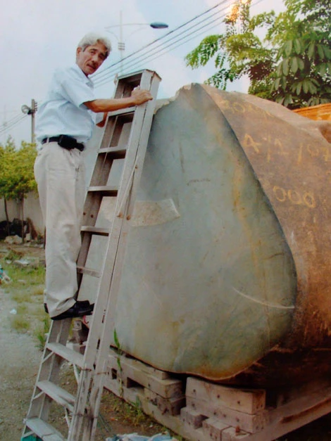 Ông Đào Trọng Cường phải bắc thang mới nhìn thấy đỉnh khối đá.