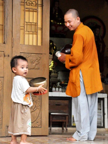 Nụ cười hạnh phúc của sư thầy Thích Chiếu Pháp với cậu bé Tiến hôm bé theo cha mẹ về thăm chùa - Ảnh: Thuận Thắng