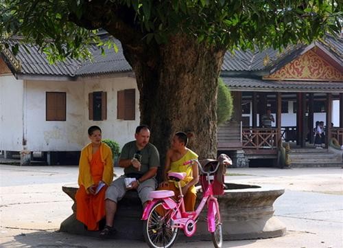 Người tu hành trò chuyện thân thiện với khách phương Tây trong sân chùa Người tu hành trò chuyện thân thiện với khách phương Tây trong sân chùa