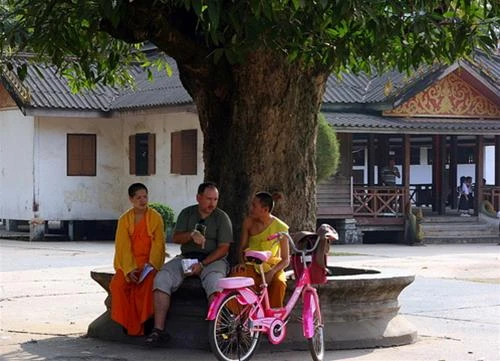 Người tu hành trò chuyện thân thiện với khách phương Tây trong sân chùa