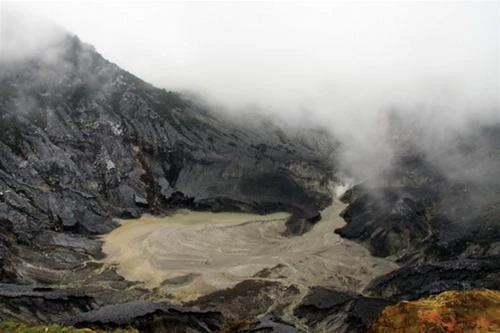 Miệng núi lửa Tangkuban Peharu trũng sâu, xám xịt và khí sulfur bao phủ đầy trời