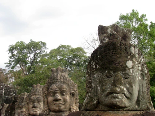 Cụm đền Angkor Wat vào buổi sớm mai. Rất nhiều du khách sẵn sàng thức dậy từ 5h sáng để kịp có mặt ngắm bình minh lên. Dù lượng khách du lịch tới Angkor rất lớn nhưng khu di tích này vẫn giữ được những nét bình yên. Bạn có nhiều lựa chọn để đi khám phá nơi đây, bằng xe đạp, thuê tuk tuk, cưỡi voi và cả bay trên khinh khí cầu. Những nụ cười bí ẩn của tượng đá khổng lồ ở đền Bayon. Những bức tượng trên đường dẫn vào Angkor Thom. Không chỉ nổi tiếng về mức độ hoành tráng, các công trình ở Angkor còn rất tinh xảo trong các đường nét chạm trổ. Không khó hiểu khi có nhiều người dành vài ngày hoặc cả tuần chỉ để thăm quan di sản văn hóa thế giới này. Không chỉ có những đền chính, nếu có thời gian bạn nên tới những đền nhỏ. Màu xanh của cây cối càng làm nổi bật thêm nét đẹp huyền bí của Angkor. Nhìn những khối đổ nát cũng đủ biết quy mô của công trình trước đây. Những rễ cây khổng lồ bao trùm lấy các bức tường, khu nhà.