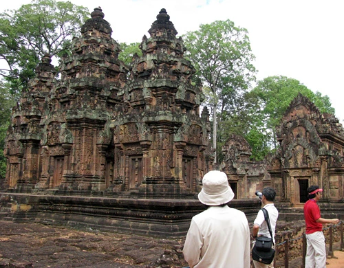 Cụm đền Angkor Wat vào buổi sớm mai. Rất nhiều du khách sẵn sàng thức dậy từ 5h sáng để kịp có mặt ngắm bình minh lên. Dù lượng khách du lịch tới Angkor rất lớn nhưng khu di tích này vẫn giữ được những nét bình yên. Bạn có nhiều lựa chọn để đi khám phá nơi đây, bằng xe đạp, thuê tuk tuk, cưỡi voi và cả bay trên khinh khí cầu. Những nụ cười bí ẩn của tượng đá khổng lồ ở đền Bayon. Những bức tượng trên đường dẫn vào Angkor Thom. Không chỉ nổi tiếng về mức độ hoành tráng, các công trình ở Angkor còn rất tinh xảo trong các đường nét chạm trổ. Không khó hiểu khi có nhiều người dành vài ngày hoặc cả tuần chỉ để thăm quan di sản văn hóa thế giới này. Không chỉ có những đền chính, nếu có thời gian bạn nên tới những đền nhỏ. Màu xanh của cây cối càng làm nổi bật thêm nét đẹp huyền bí của Angkor. Nhìn những khối đổ nát cũng đủ biết quy mô của công trình trước đây. Những rễ cây khổng lồ bao trùm lấy các bức tường, khu nhà.