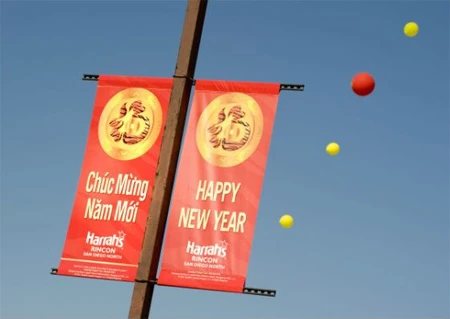 Hai tấm băng rôn có chữ chúc mừng năm mới bằng tiếng Anh và tiếng Việt treo tại hội chợ.