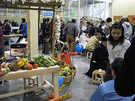 Gian bán hoa quả trong làng. Phía xa là đám đông đang tập trung chơi cờ tướng. Làng Việt Nam nằm trong hội chợ CNE ở Toronto.