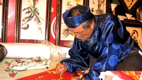 Hình ảnh ông đồ già trên phố ngày nay vẫn không khác xưa là mấy. Cũng áo dài, khăn đóng, cũng mực, cũng nghiên với nét bút "rồng bay phượng múa".