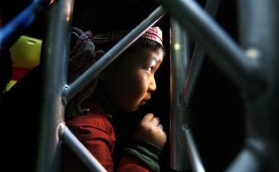 Matthew Lê, 8 tuổi, học sinh của trường Tiểu học Việt Nam Văn Lang nhìn màn trình diễn mừng năm mới Canh Dần tại Seattle Center House qua khe cửa.